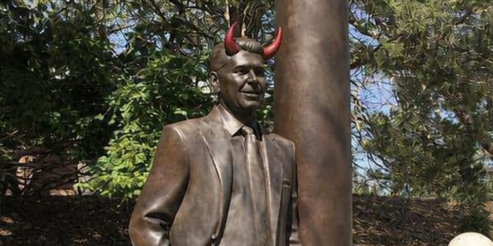 A statue or Ronald Reagan, the devil himself, showing his horns.